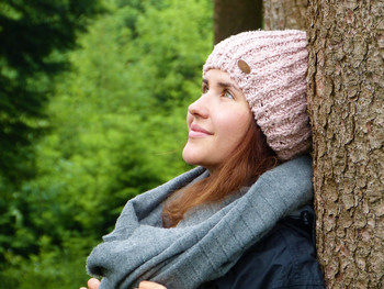 Junge Frau angelehnt an einen Baum